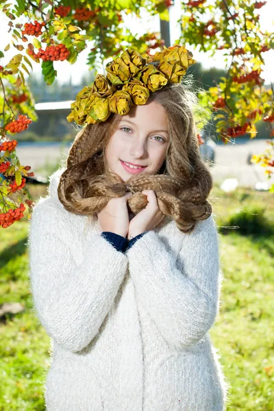 Menina com uma grinalda de folhas de outono — Fotografia de Stock