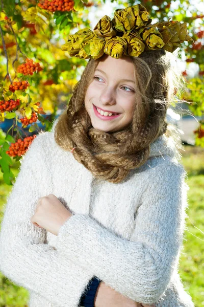 Menina com uma grinalda de folhas de outono — Fotografia de Stock