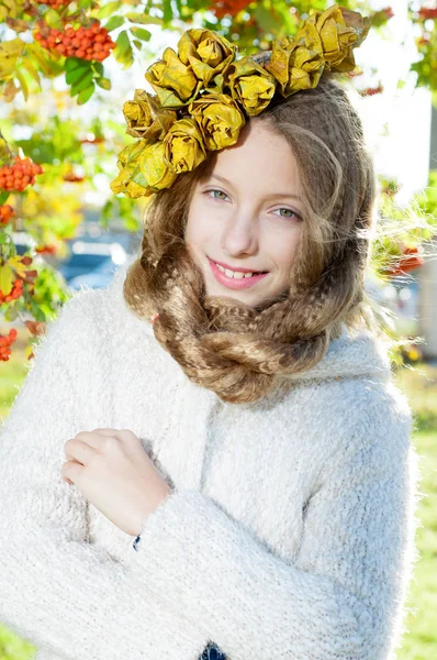 Menina com uma grinalda de folhas de outono — Fotografia de Stock