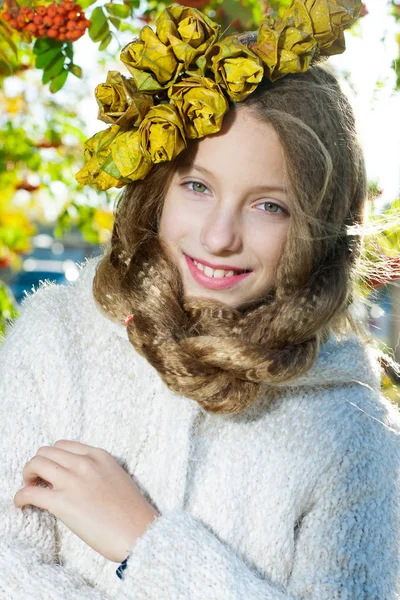 Menina com uma grinalda de folhas de outono — Fotografia de Stock