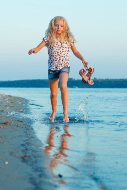 plajda çıplak ayakla su üzerinde çalışan kız