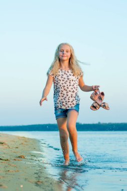 plajda çıplak ayakla su üzerinde çalışan kız