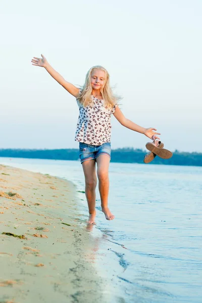 Girl running on the beach at the water barefoot — Stock Photo, Image
