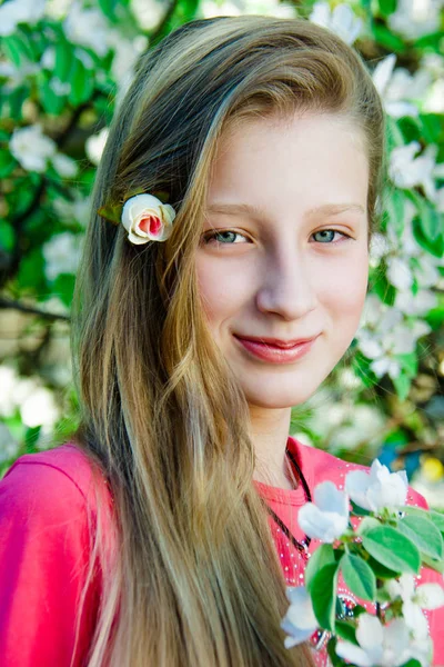 Menina no fundo de uma árvore florescente — Fotografia de Stock