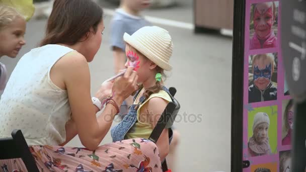 MOSCOW, RUSSIA, JUNE 18, 2016: Street Artist Painting Face Of The Little Girl — Stock Video