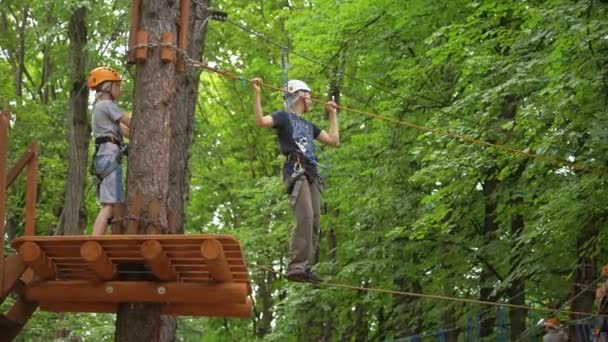 MOSCOU, RUSSIE, 18 JUIN 2016 : De nombreux enfants traversent un obstacle à la boucle de corde dans un parc d'aventure — Video