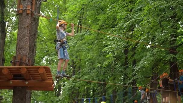 MOSCOW, RÚSSIA, 18 DE JUNHO DE 2016: Obstáculo de equilíbrio de corda de passagem de menino adolescente no parque de aventura — Vídeo de Stock