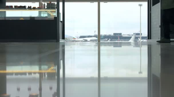 Барселона, Іспанія, 30 квітня 2016: Людина з чемодан, Проходячи повз вікна в аеропорту — стокове відео