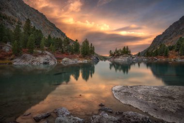 Kayalar ve günbatımı dağ gölü, Altay Dağları Yaylası doğa sonbahar manzara fotoğraf pembe sularda yansıtan ağaçlar