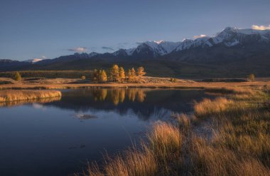 Dağ gölü sonbahar manzara ve şapkalı kar Dağları bir arka plan üzerinde