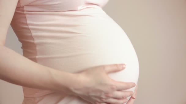 Mujer embarazada tocándose el vientre con las manos — Vídeo de stock