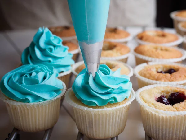 Sütés cupcakes. Krém vezetője a zsák péksütemény gyártás — Stock Fotó