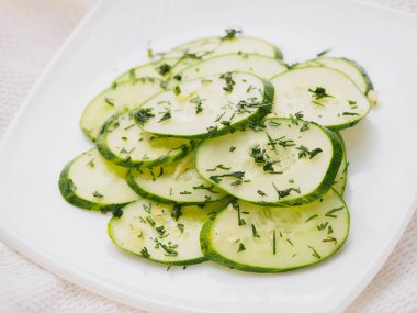 Salatalık dereotu ile beyaz tabağa dilimlenmiş