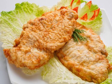 meyilli beyaz tabakta yeşillikleri ile balık