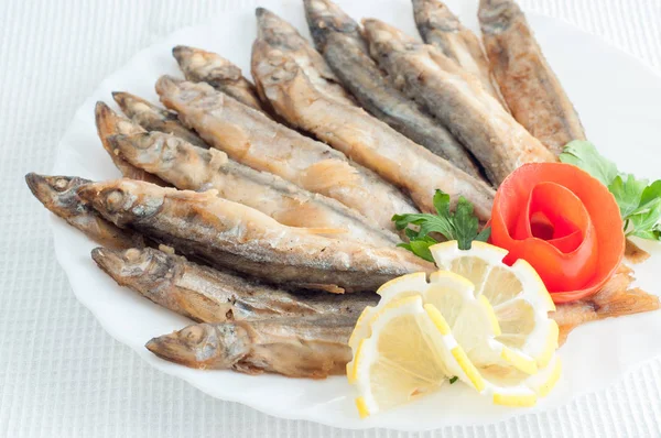 Peixe de anchova de espadilha com limão em um prato branco — Fotografia de Stock