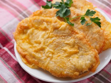 meyilli beyaz tabakta yeşillikleri ile balık