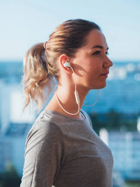 Wireless headphones in ears of young woman