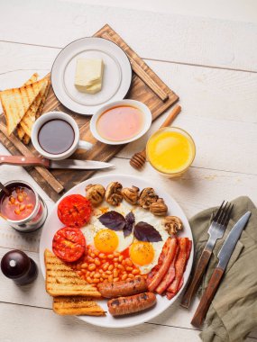 Tam İngiliz kahvaltısı dahil sosis, ızgara domates ve mantar, yumurta, pastırma, Kuru fasulye, ekmek ile portakal suyu