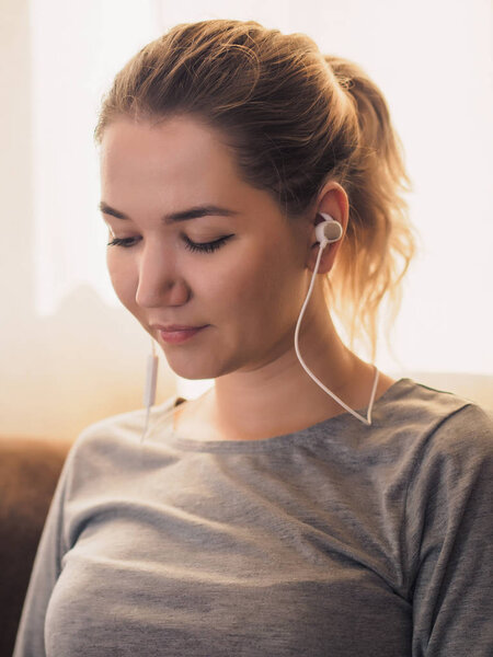 Wireless headphones in ears of young woman