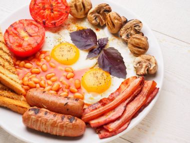 Tam İngiliz kahvaltısı dahil sosis, ızgara domates ve mantar, yumurta, pastırma, Kuru fasulye, ekmek ile portakal suyu