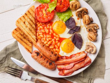 Tam İngiliz kahvaltısı dahil sosis, ızgara domates ve mantar, yumurta, pastırma, Kuru fasulye, ekmek ile portakal suyu