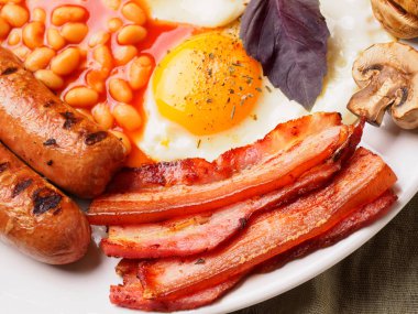 Tam İngiliz kahvaltısı dahil sosis, ızgara domates ve mantar, yumurta, pastırma, Kuru fasulye, ekmek