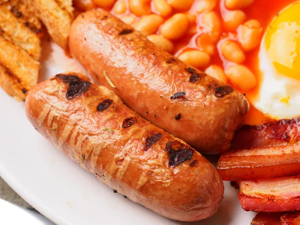 Desayuno inglés completo con salchichas, tomates y champiñones a la parrilla, huevo, tocino, frijoles horneados, pan — Foto de Stock