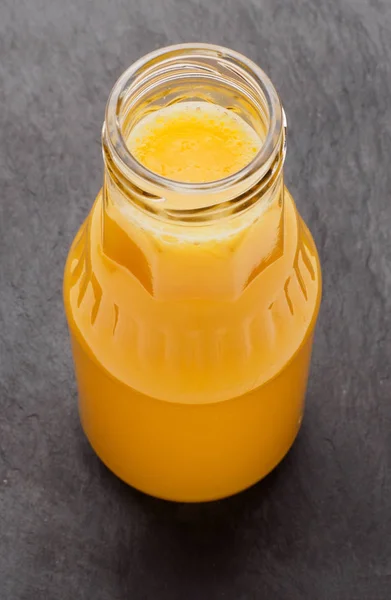 Portakal suyu şişesi, siyah arka plan üzerine izole — Stok fotoğraf