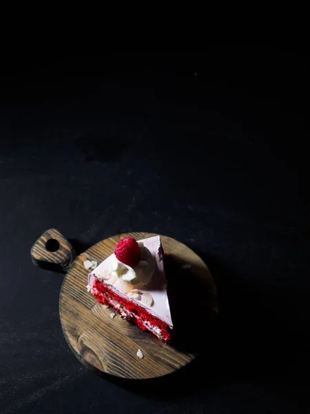 Pedazo de pastel sobre tabla de madera. fondo negro —  Fotos de Stock