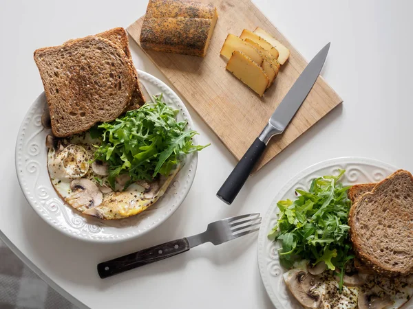 Omelete ovos com cogumelos e arugula. Café da manhã com queijo e pão — Fotografia de Stock