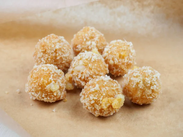 Tasty cheese balls on paper for baking