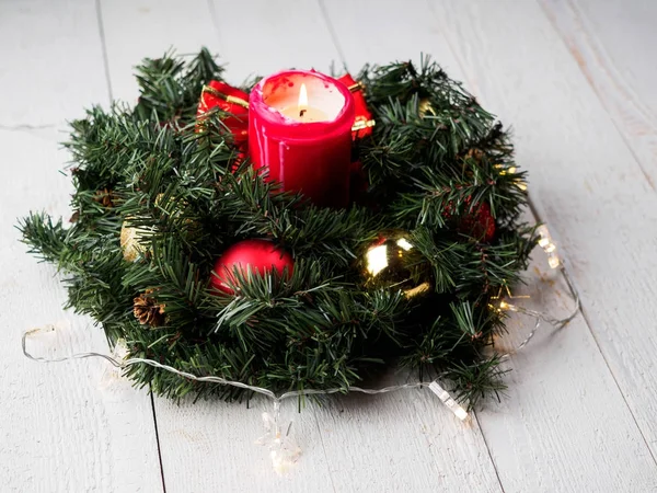 Christmas spruce branch wreath with candle on the wood board