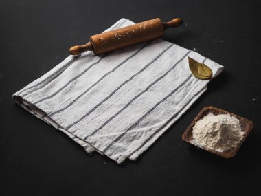 oklava ve siyah arka plan üzerine peçete ile un