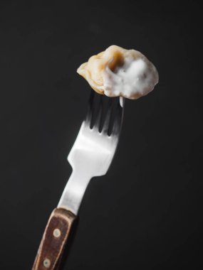 Ahşap çatal üzerinde ekşi krema ile hamur tatlısı. siyah arka plan