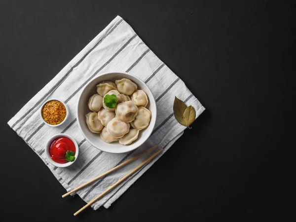 Dumplings on plate at wooden desk on black background — Stock Photo, Image