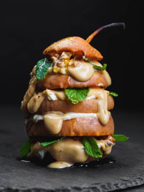 Fıstık ezmesi ile pişmiş armut siyah arka plan üzerine dilimlenmiş