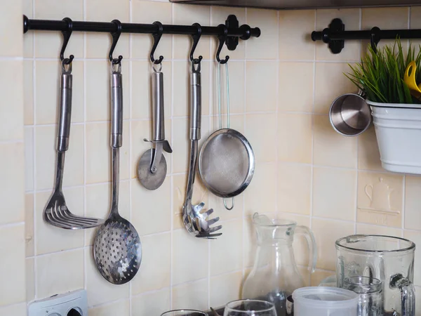 Kitchen metal chrome tools on the rail — Stock Photo, Image