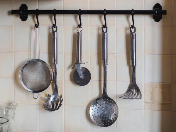Кухонные металлические хромированные инструменты на перилах — стоковое фото