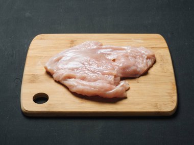 ahşap tahta üzerinde çiğ tavuk fileto. siyah arka plan