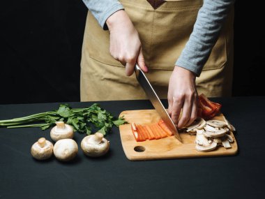 Kadın kesme çiğ kırmızı biber ahşap tahta üzerinde
