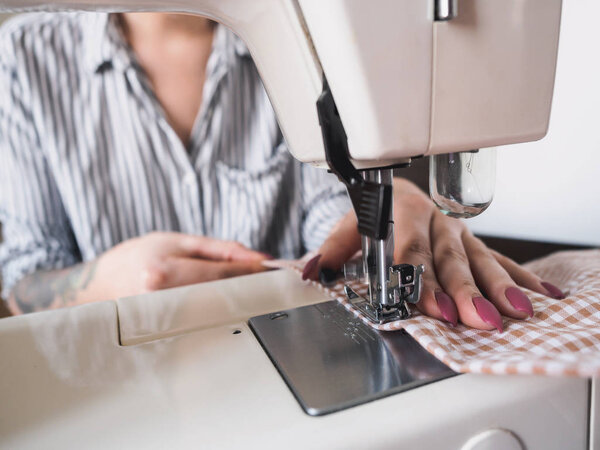 Девушка работает на швейной машине с текстильными салфетками
