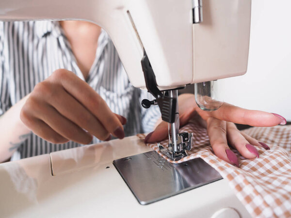 Girl working on sewing machine with textile napkins