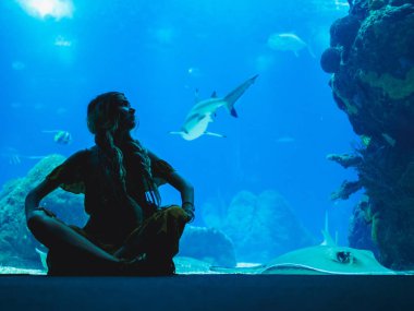 Balık Oceanarium bardakta aracılığıyla izlerken kız