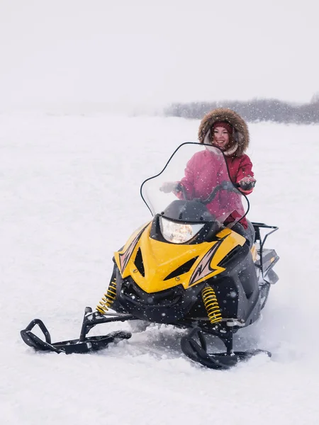 Meisje in de sneeuwscooter. Winter sneeuwveld — Stockfoto