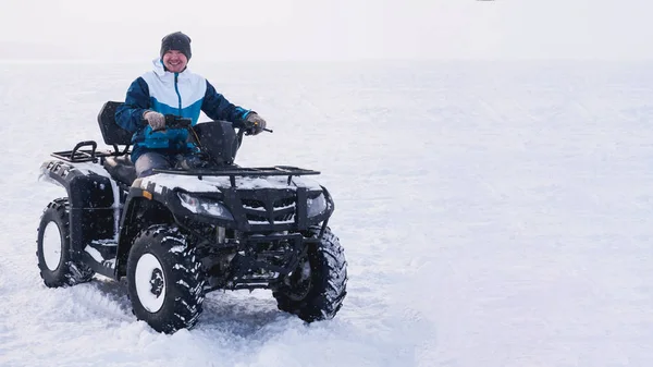 Man in atv quad bike. Winter sneeuwveld — Stockfoto