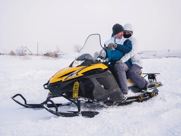 Paar van man en vrouw in de sneeuwscooter. Winter sneeuwveld — Stockfoto