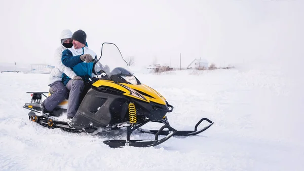 Para mężczyzna i kobieta w skuterze. Zima snow pola — Zdjęcie stockowe