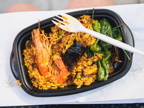 Paella clásica con arroz y pimienta de camarón en plato de plástico negro — Foto de Stock