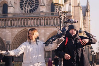 Notre Dame Katedrali önünde meydanında güvercin besleme turist