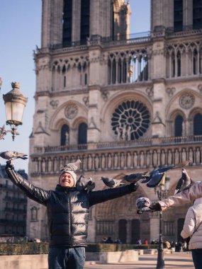 Notre Dame Katedrali önünde meydanında güvercin besleme adam